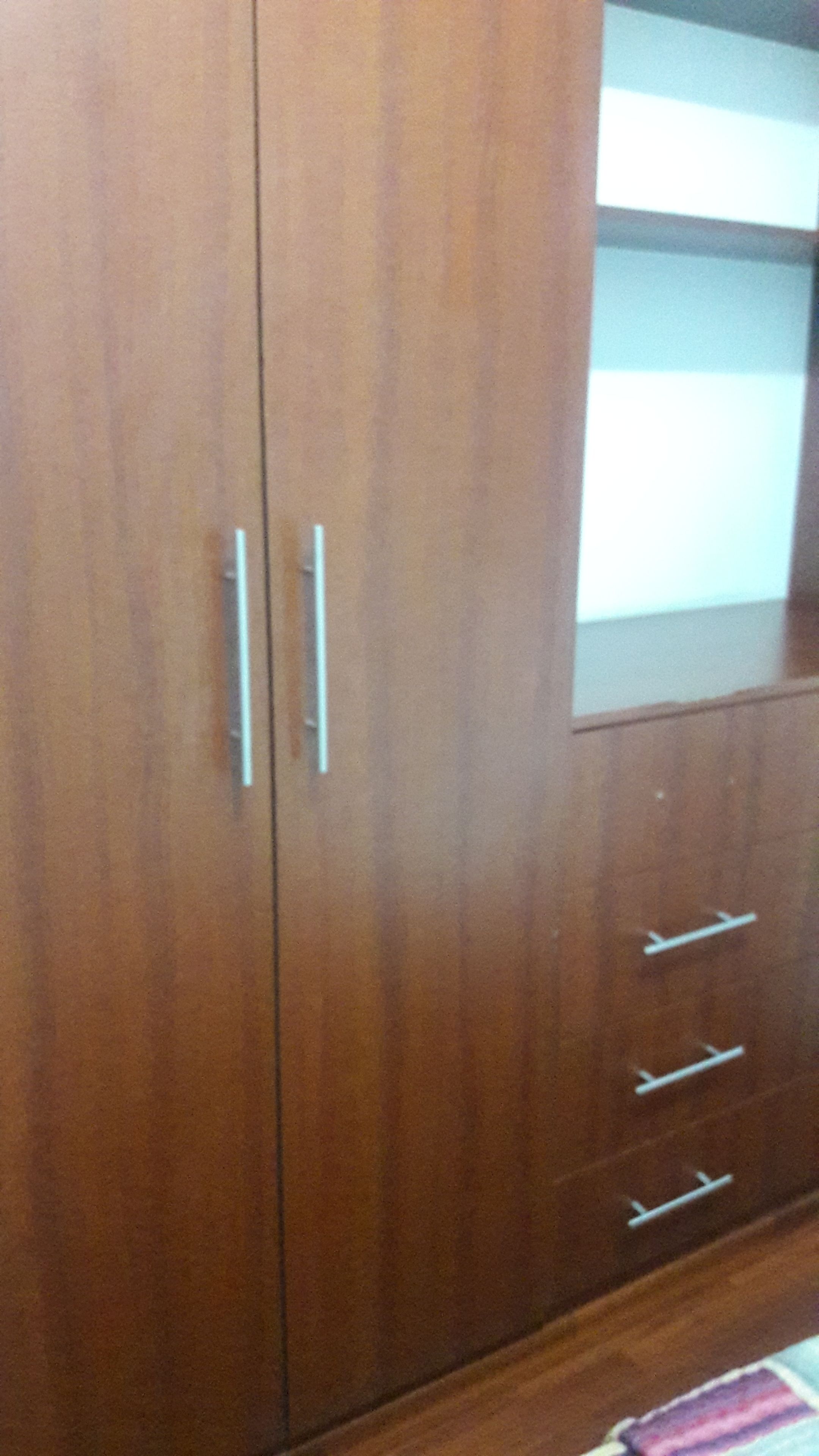 Un armario de madera con dos puertas y tres cajones.