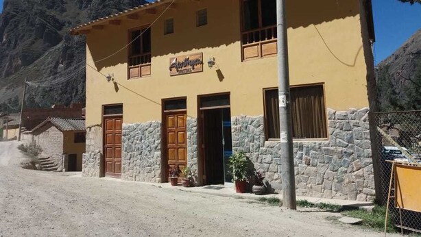 A two-story building with a sign reading "Alhambra Hostal" on the facade.