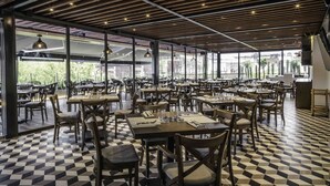 A spacious restaurant with checkered flooring, wooden tables and chairs, and large windows offering views of the outdoors. - Domingo Santo Hotel Boutique - Adults Only (Mexico City)