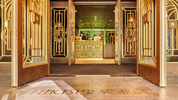 Ein Hotel mit Eingangsbereich, einer Rezeption und einem Schild mit der Aufschrift 'ILECESTER SQUARE'.