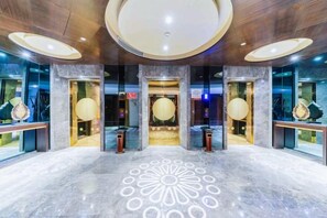 A lobby with a circular floor pattern, a reception desk, and a large chandelier. - Gophoe Hotel (Huizhou City)
