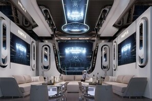 A modern interior with a central seating area, large screens, and a futuristic design. - Gophoe Hotel (Huizhou City)