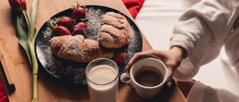 Una bandeja de desayuno con pasteles, fresas y un vaso de leche sobre una mesa de madera.