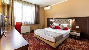A hotel room with a bed, a desk, a chair, and a television. - Business Hotel Plovdiv (Plovdiv)