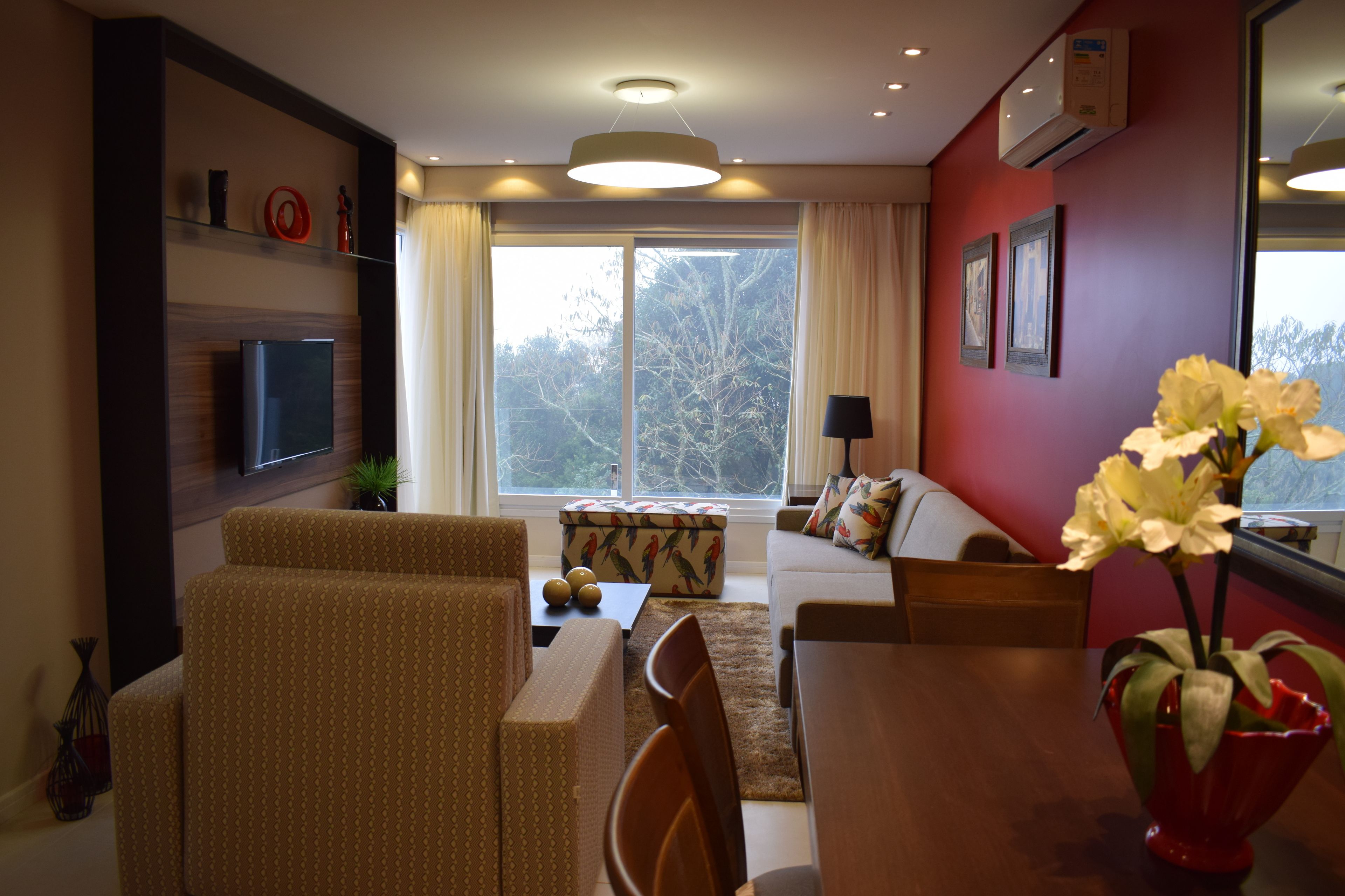 Una sala de estar moderna con un sofá, sillas, una mesa de centro y un televisor.
