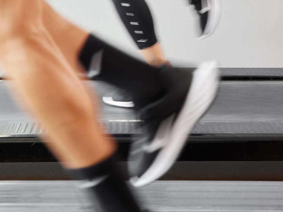 A blurred view of a treadmill with a person using it.