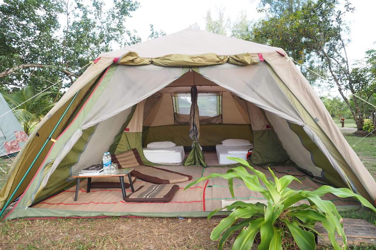 A tent with a sleeping area, a small table, and a water bottle.