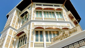 Un edificio de varios pisos con balcones ornamentados y un cartel que dice "CHUCHAI BURI".