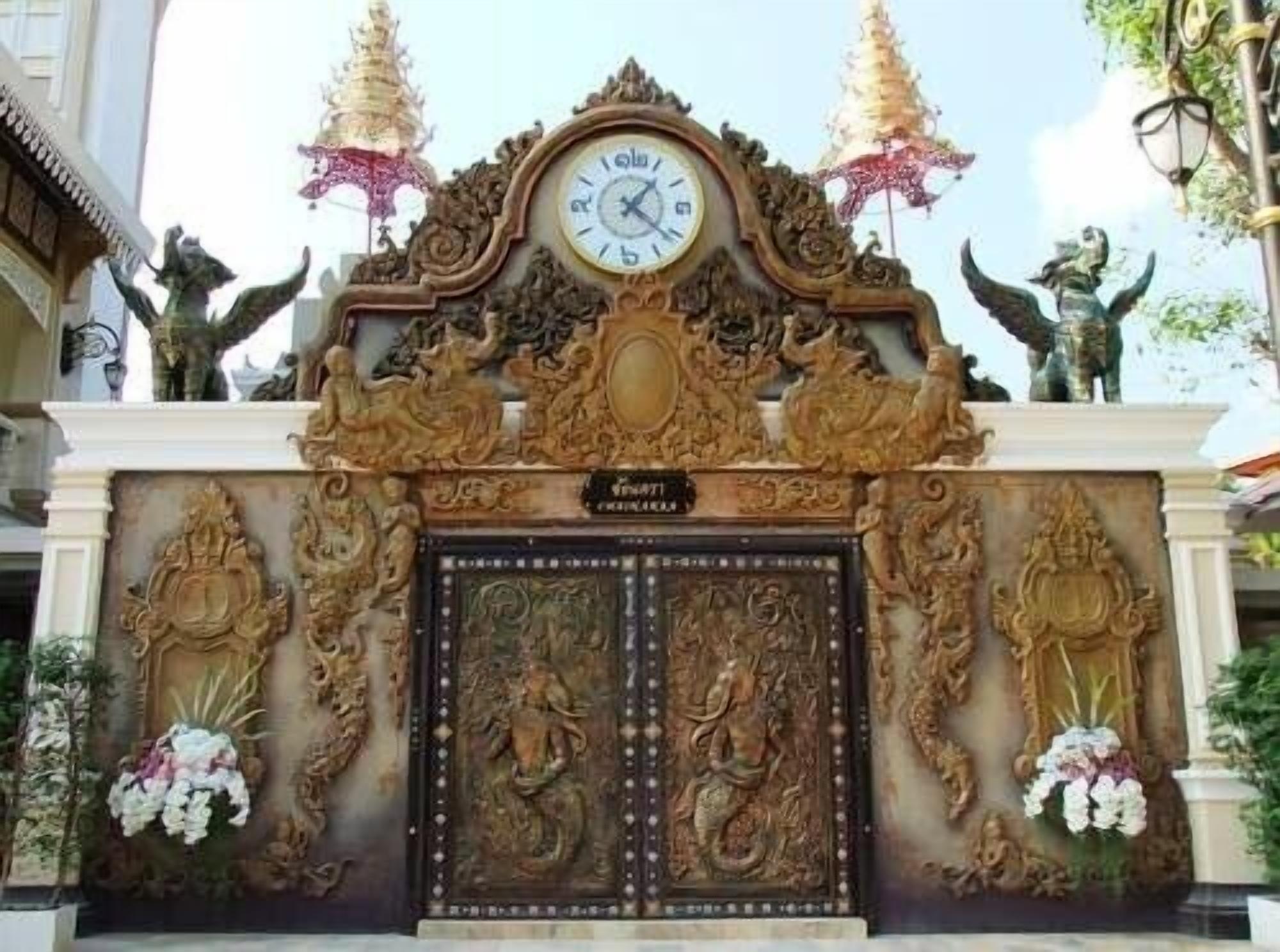 A detailed entrance with ornate carvings, a clock, and statues.