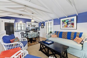 A living room with a sofa, a dining table with chairs, and a kitchen area with a refrigerator and microwave. - Best Beach Location in Santa Monica! Our Summer Stretches Through Fall! (Santa Monica)