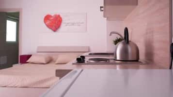 A modern bedroom with a bed, a kettle, and a wall-mounted heart-shaped decoration.