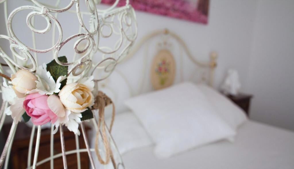 A bed with a white headboard and a white pillow.