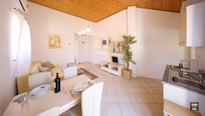 A modern kitchen with a sink, stove, and dining area with a table set for two.