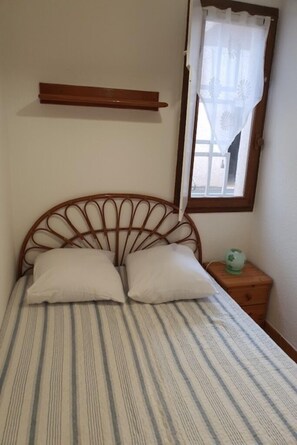 2 dormitorios y tabla de planchar con plancha