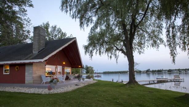 A lakeside cabin with a patio, outdoor seating, and a dock. - Door County's Chalet On The Shore (Sturgeon Bay)