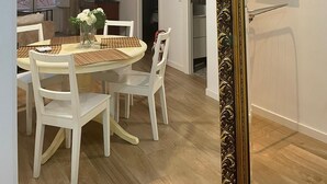 A dining area with a round table, white chairs, and hanging pendant lights. - Exterior, balconies, terrace, 2 bathrooms, wifi, next to subway and train. (Madrid)