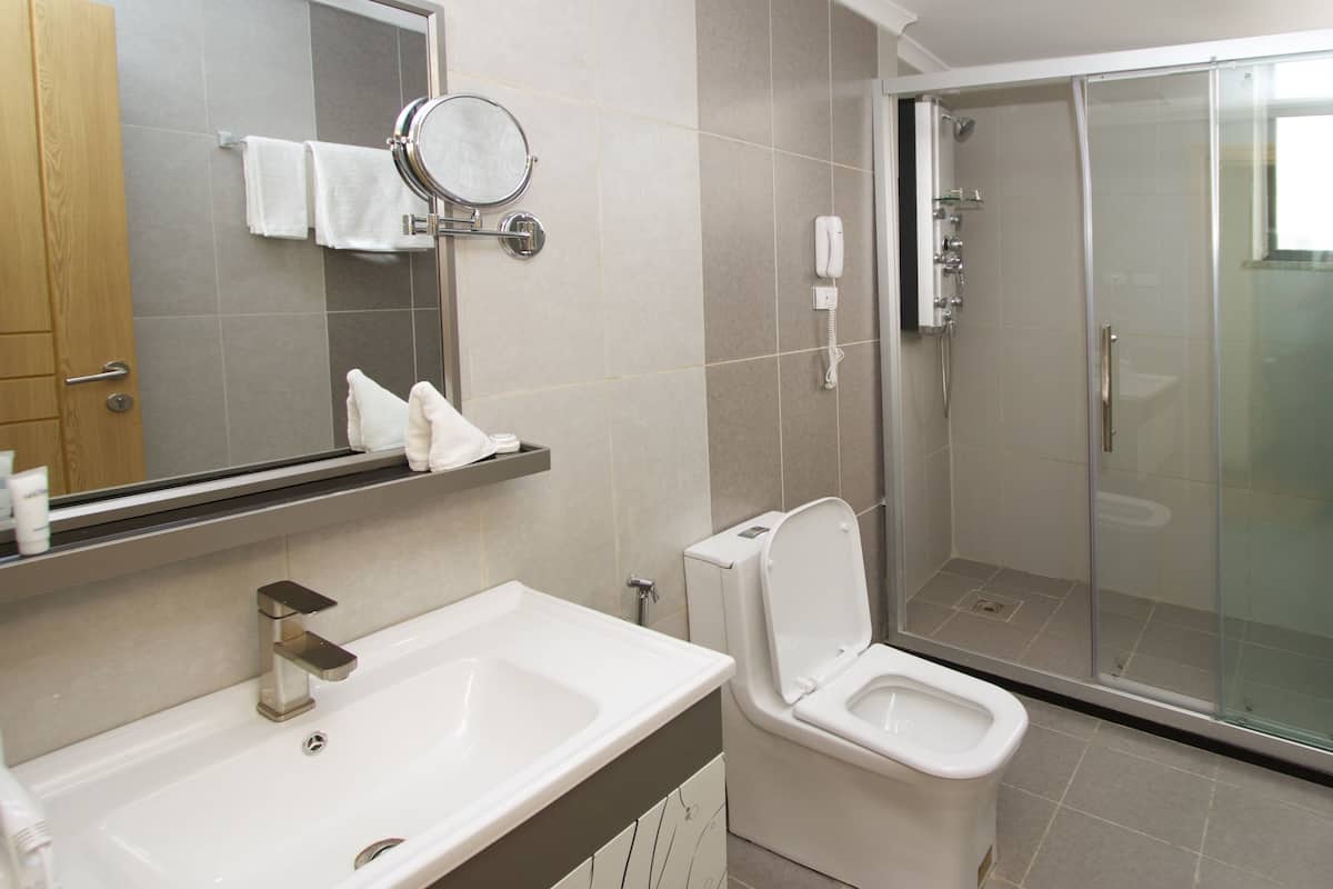 A modern bathroom with a toilet, sink, and glass-enclosed shower.