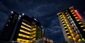 A hotel with multiple floors, illuminated windows, and a prominent red sign. - Yober Hotel (Addis Ababa)