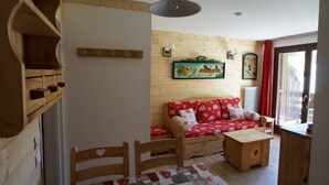 Ein gemütliches Zimmer mit einer Holzsofa, einem kleinen Holztisch und einer gesteppten Tischläufer.