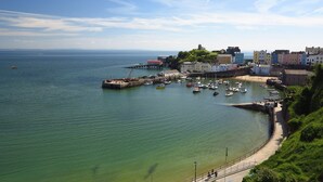 A coastal town with a marina, buildings along the shore, and a clear view of the sea. - Sea View Apartment Tenby, Pembrokeshire, Wales. Near Beach, Restaurants & Shops (Tenby)