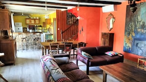 A living room with a sofa, a wooden coffee table, and a dining area with a table and chairs.
