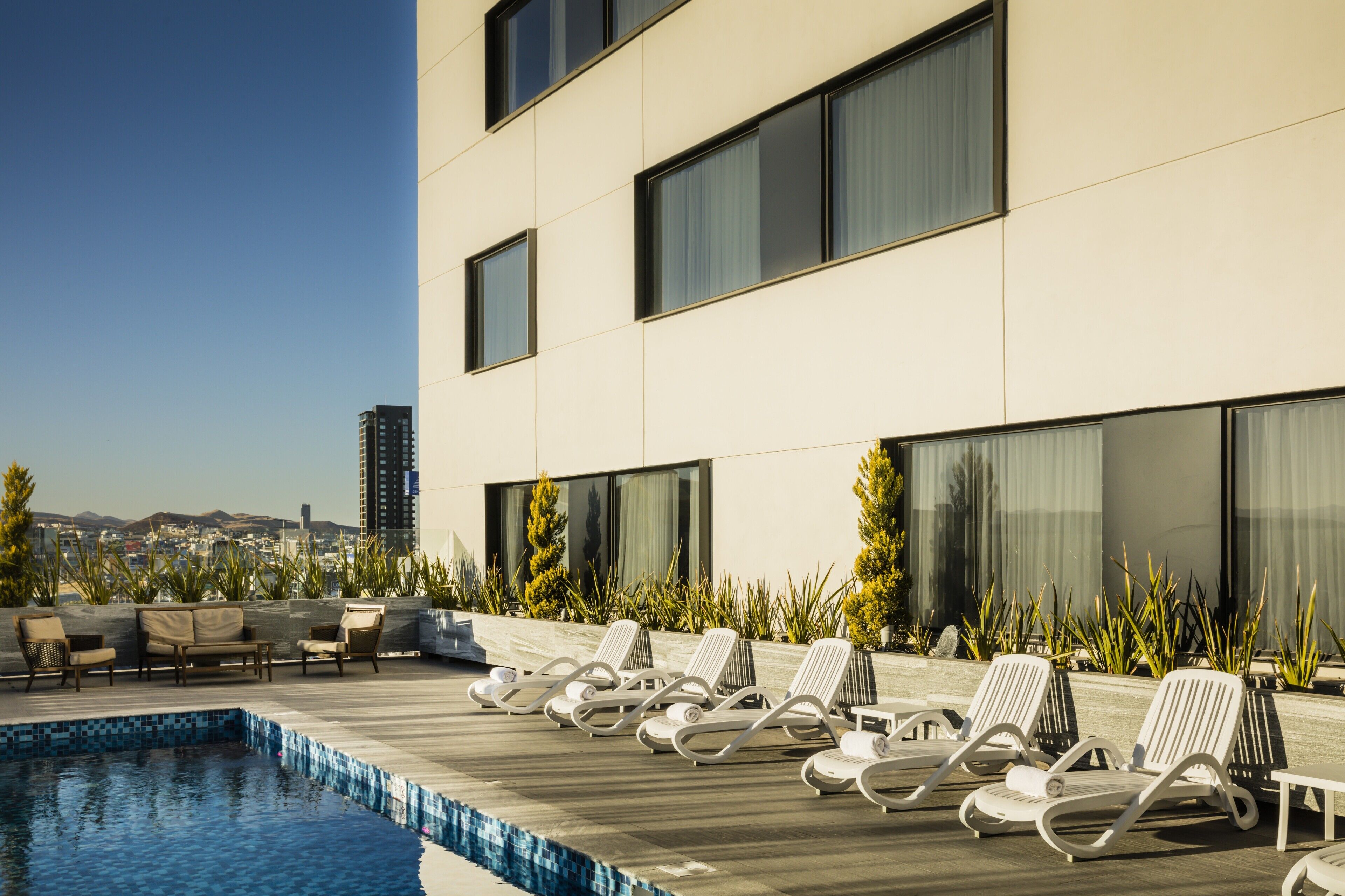 Una piscina al aire libre, sillones reclinables de piscina