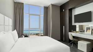 Ein modernes Hotelzimmer mit einem großen Bett, einem Schreibtisch und einem Fernseher.