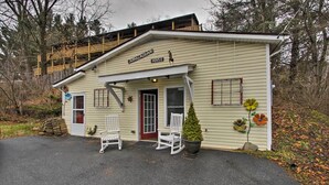 A small, single-story building with a sign reading "Appalachian House." There are two white rocking chairs in front of the entrance, a small potted plant, and a decorative flower on the wall.