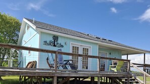 A light blue building with a porch and a staircase leading to a covered area. - Sportsman's Paradise Lodge Seadrift (Seadrift)