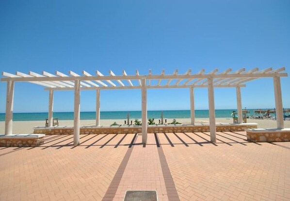 A beachside pergola structure with a clear view of the ocean.