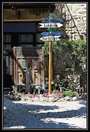 A directional signpost with multiple arrows pointing to various destinations such as Mt Ventoux, Luberon, St Renny, Arles, and Pont Du Gard.