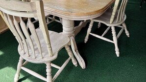 A wooden table and chairs set up in a covered area with large windows overlooking a lake. - Lakeside Adirondack Lodge (Tupper Lake)