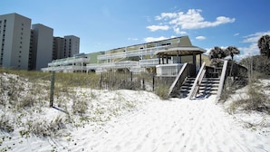 A hotel with a beachside location, featuring a staircase leading to a covered area with a view of the ocean. - Townhouse condo. 3 min walk to private beach.  1 min walk to pool.  (Destin)