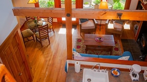A spacious loft-style room with a dining area, seating, and a kitchen. - Cottage-in-the-Barn on Dragonfly Farm (Eastsound)