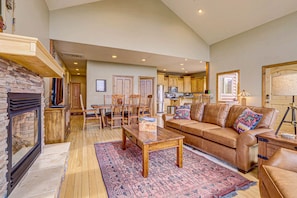 A spacious living room with a fireplace, a large brown leather sofa, a coffee table, and a patterned rug. - Buffalo Ridge on Zion Boundary very close to the Park! Gated Community -Hot Tub (Mt Carmel)