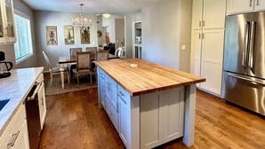 A modern kitchen with a central island, stainless steel appliances, and wooden flooring. - Charm and Modern Luxury in Heart of Wine Country (Sonoma)