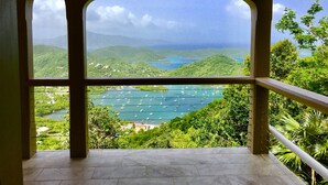 A view from a balcony with a clear sky, lush greenery, and a body of water with boats. - HEAVENLY VIEWS and PRIVATE POOL!! (Coral Bay)
