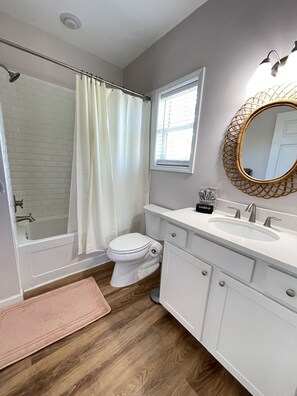 A bathroom with a shower, toilet, sink, and vanity. - The Osceola House at Indian Pass (Port St. Joe)