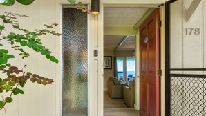 A hallway with a frosted glass door, a red door, and a number 178 on the wall. - Direct Oceanfront Condo on Private Beach Resort *Central AC * (Kailua-Kona)