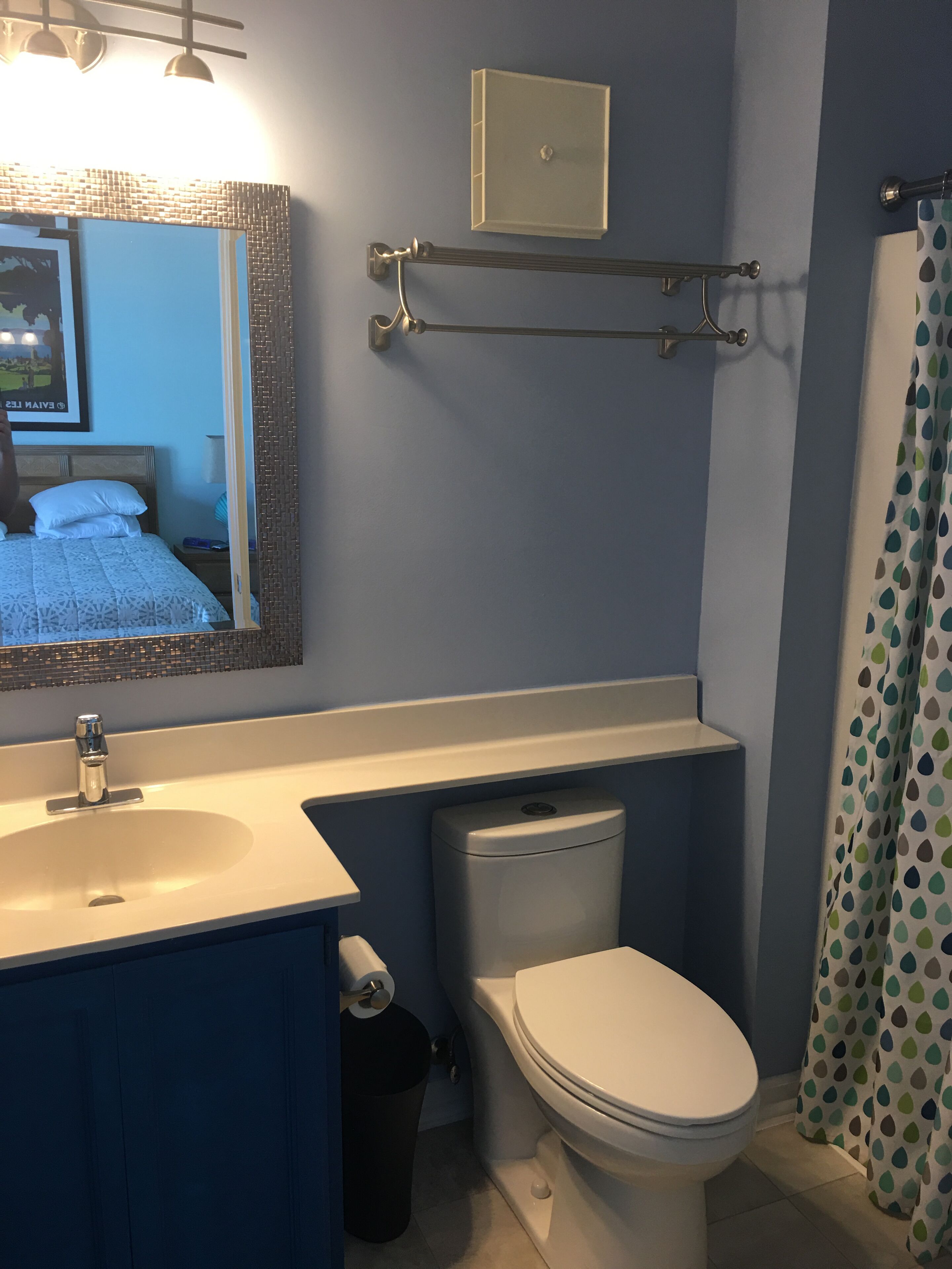 A bathroom with a sink, toilet, and a mirror.