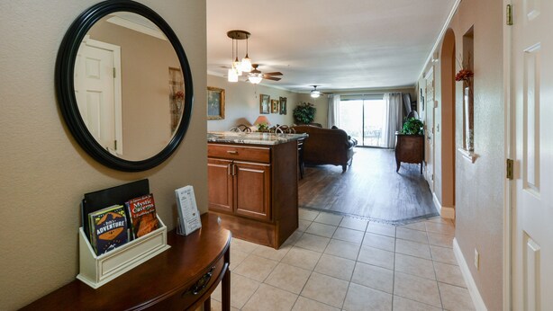 A spacious hallway with a kitchen area, a dining table, and a large mirror.