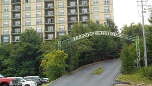 A multi-story hotel with balconies and a sign reading "Mountain View Condos". - STAY NEAR THE STRIP, ONE MINUTE OFF PARKWAY WITH SENSATIONAL VIEWS. (pigeon forge)