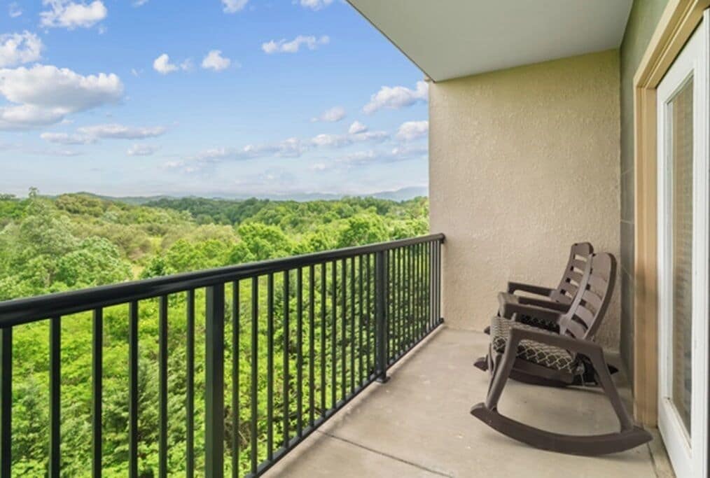 Ein Balkon mit Blick auf eine bewaldete Landschaft.