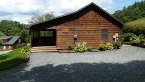 Eine Holzhütte mit Veranda, Briefkasten und einem Schotterweg.