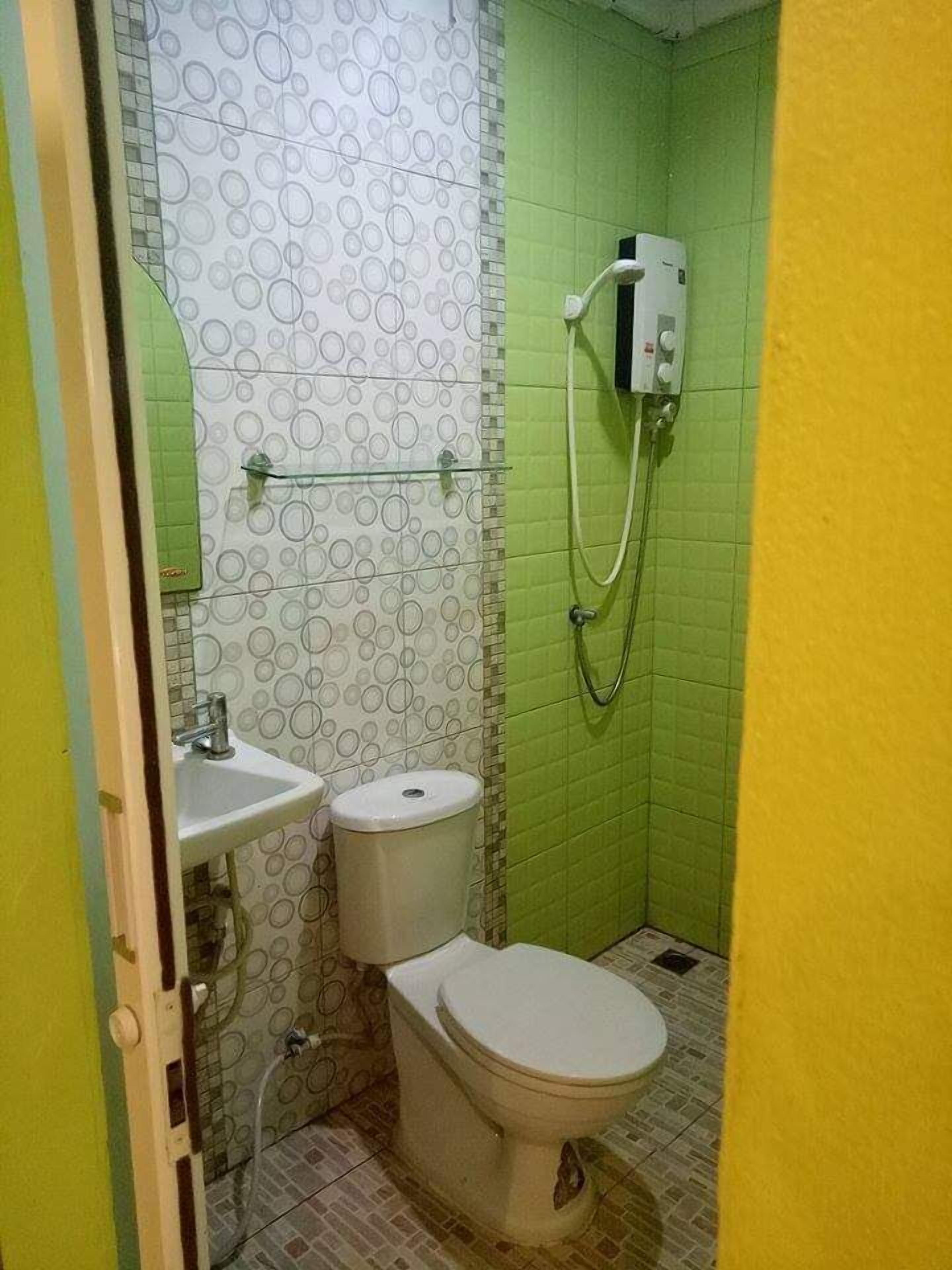 A small bathroom with a toilet, sink, and shower.