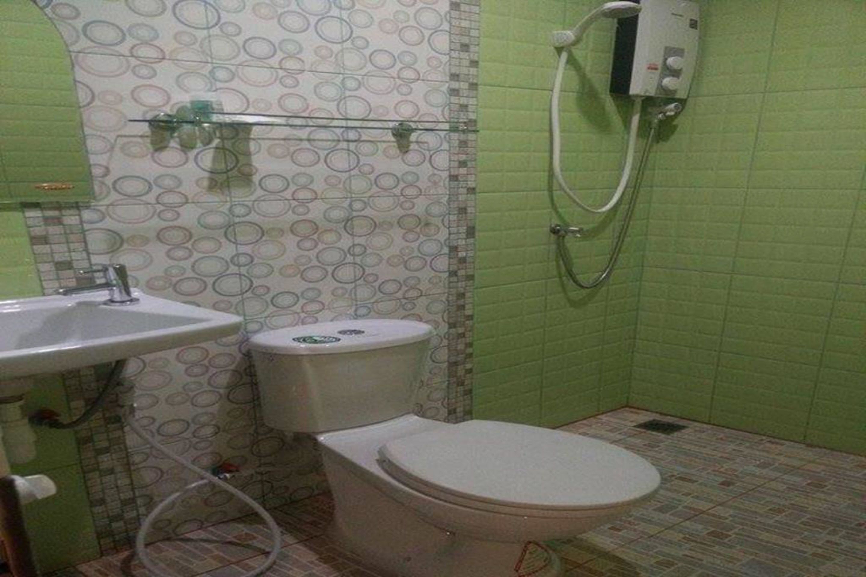 A bathroom with a toilet, sink, and shower.