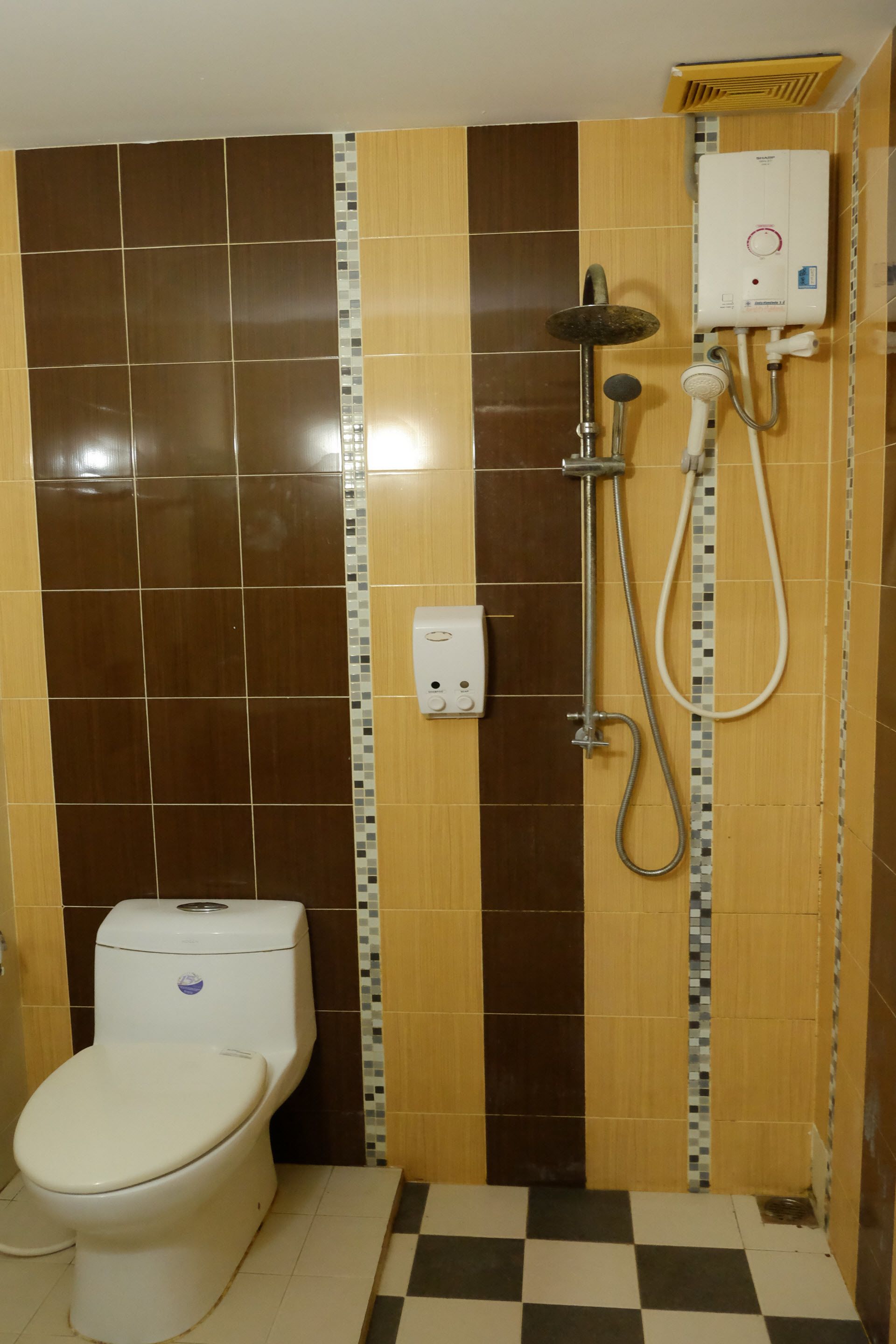 Une salle de bain équipée de toilettes, d’une douche et d’un radiateur fixé au mur.