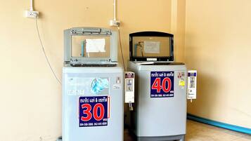 Dos dispensadores de agua, uno etiquetado con el número 30 y el otro con el número 40, frente a una pared beige con suelo de baldosas.