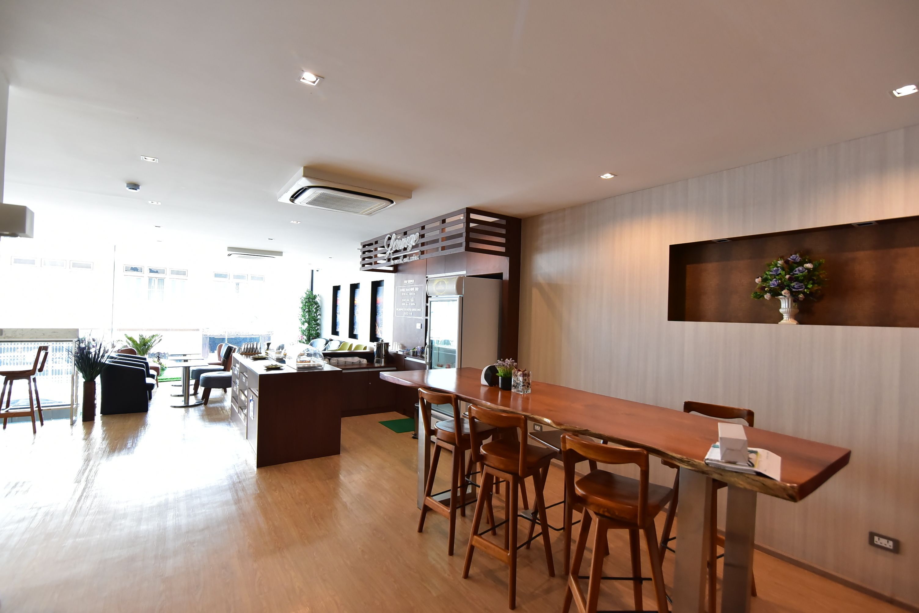 A modern kitchen with a wooden island, bar stools, and a large window.