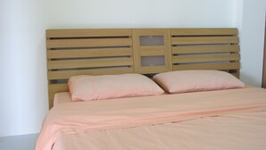 A bed with a wooden headboard and two pillows. - Boonya Place (Chonburi)